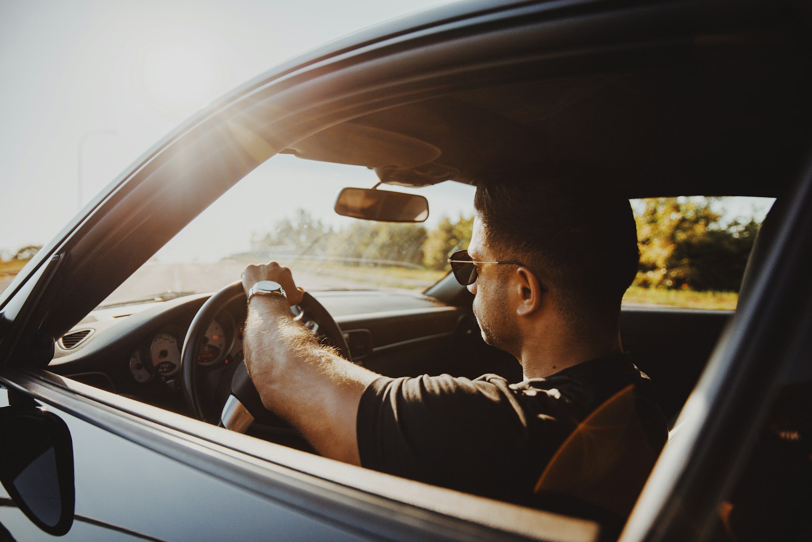 man in black jacket driving car during daytime, auto